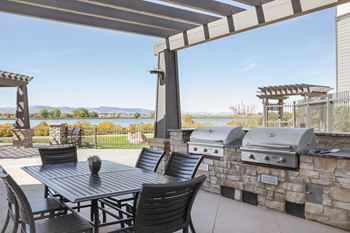 a patio with a grill and a table and chairs